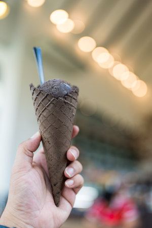 Man holds delicious chocolate Ice cream in the waffle cone. Ice cream cone in hand
