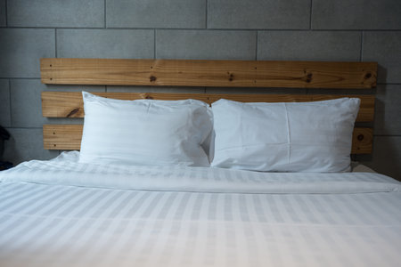 Close up of white pillow twin bed, king size bed at hotel against a block wall, design and relaxationの写真素材