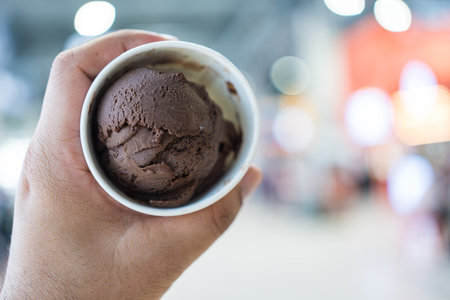 Chocolate ice cream in paper cup on handの写真素材