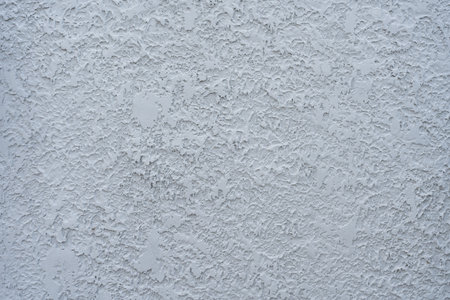 White cement wall panel with a rough pattern. The design consists of irregular