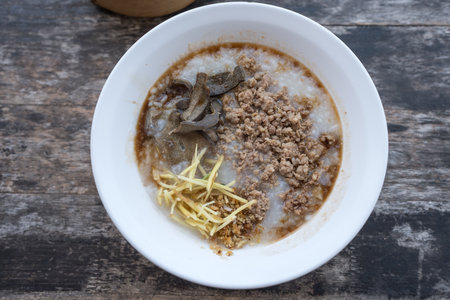 Rice porridge with minced pork served on white bowlの写真素材
