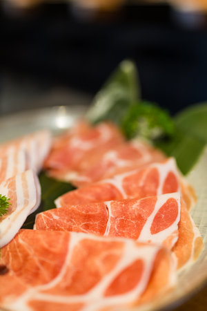 Beautiful composition of raw pork slices paper thin and elegantly rolledの写真素材