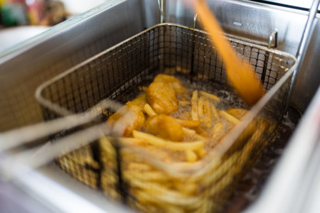 Deep frying chips and nuggets in a professional kitchen frying. Close upの写真素材