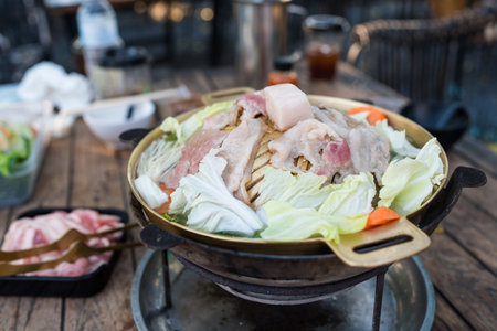 Lard meats on a hot frying pan, eating Thai style barbecue. Its name is called Moo Ka Ta, a popular food among Thai people on holidays. Grilled food style Pork or sea beef and boiled vegetables.の写真素材