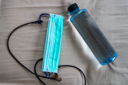 A bottle of water and a mask on bedの写真素材