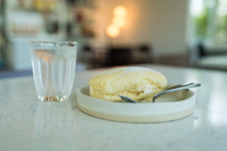 Close up of a delicious long roll filled with white cream with powdered sugarの写真素材