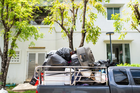 Pickup truck loaded with used goods and other scrap. Ready for recycling or disposal in sunny outdoor setting.の写真素材