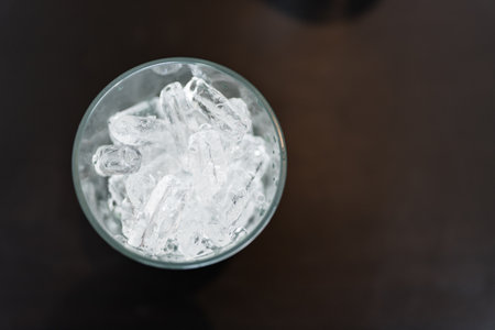 Top view of a glass filled with ice on black tableの写真素材