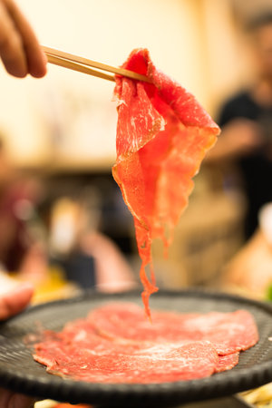 Delicious raw beef shabu shabu on wood chopsticksの写真素材