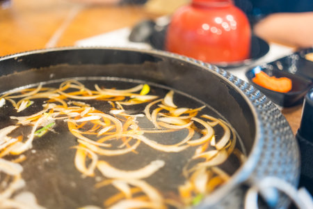 Boiled black soup sukiyaki in pot with ingredients. Close upの写真素材