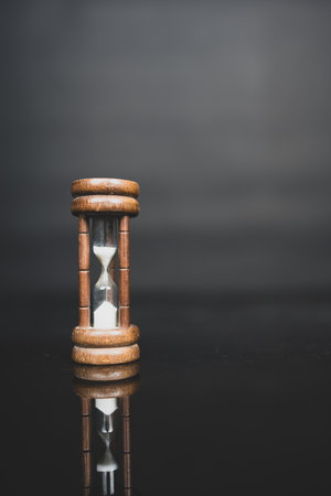 Hourglass on black background. Hourglass time with sand running through