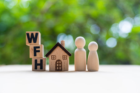 Wooden cubes with texting message WFH and placed together with wood model home and peg doll. Online work through media networking concept. Community and business remote working meeting theme.の写真素材