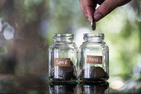 Saving money for teavel and vacation. Money savings in glass jar. Travel concept.の写真素材