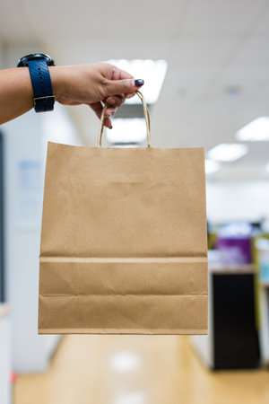 Woman holding empty brown paper bag in a mallの写真素材