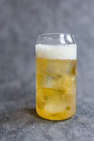 A glass of cold beer with iced and foamの写真素材