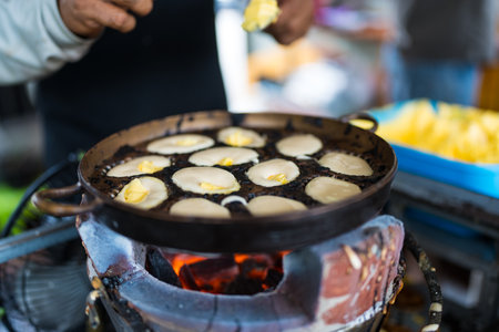 Khanom Khai in hot pan make by Thai trader, Khanom Khai is a Thai oval sweetmeat made with egg and...