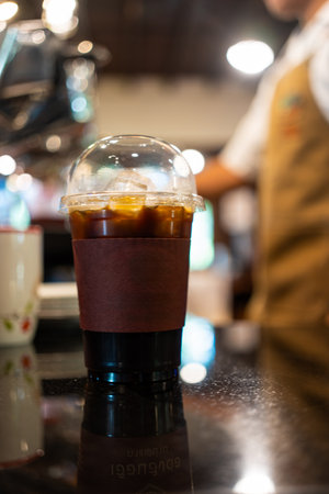 Iced Americano with a blurred background of a male barista at coffee shop.