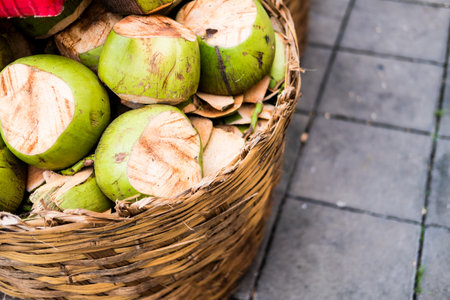 Green coconuts in a wicker basket on the market