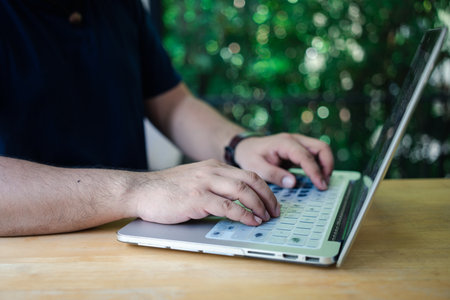 Shot of an unrecognizable man working on his laptop in home officeの写真素材