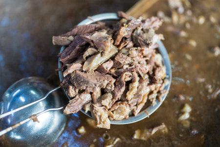 Stewed beef and offal pick from the hot soup. Close up