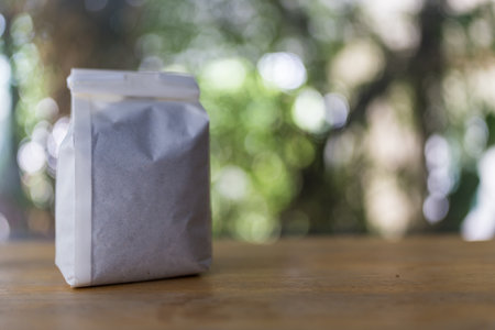 Coffee powder in white packaging on wood tableの写真素材