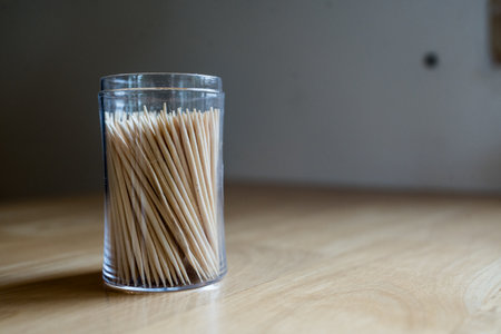 Toothpick in plastic circle box on wood tableの写真素材