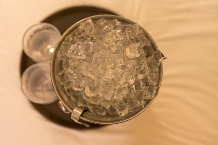Top view of a bucket filled with ice placed on a white bed in a luxury hotelの写真素材