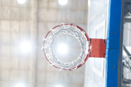 A close up of a basketball hoop with a red rim and a white netの写真素材