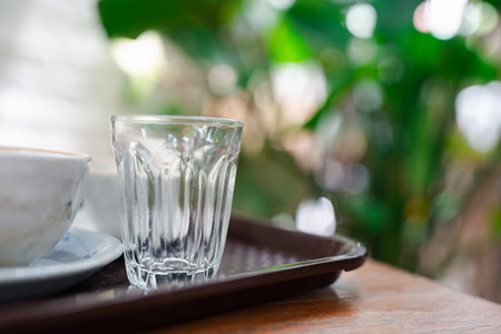 Empty shot glass on a table against nature backgroundの写真素材