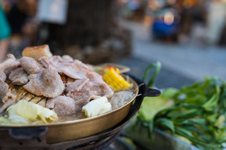 Eating grilled pork with vegetable and soup in hot pan. Thai style cuisineの写真素材