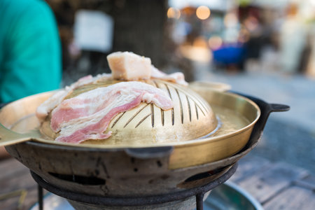Thai barbecue Grill Pork on hot pan. Barbecue buffet pig pan and vegetables in soup.の写真素材