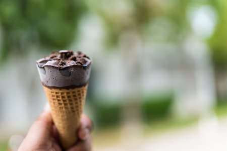Chocolate ice cream in hand against nature backgroundの写真素材