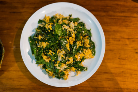 Stir fried Malindjo leaves with egg on the table, this menu is favorite in the south of Thailandの写真素材
