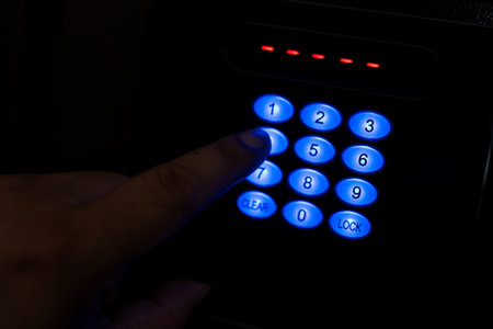 Action of people hand is unlocking to open the safe box door by pressing password on the number panel.の写真素材