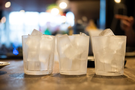Ice cubes in a glass on wood tableの写真素材