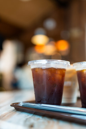 Refreshing iced black americano coffee in a takeaway cup in cafe