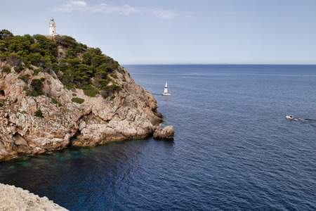 Sailboat on rocky cliffs by the seaの写真素材
