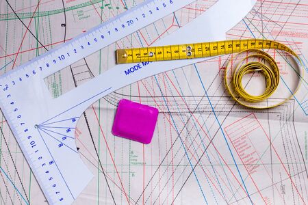 Sewing tools, tape measure, ruler and chalk on a sewing pattern