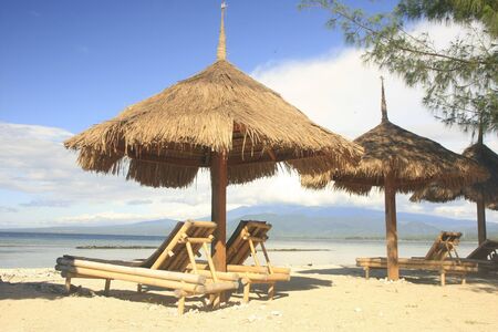 Sun chairs and umbrellas on a beachの写真素材
