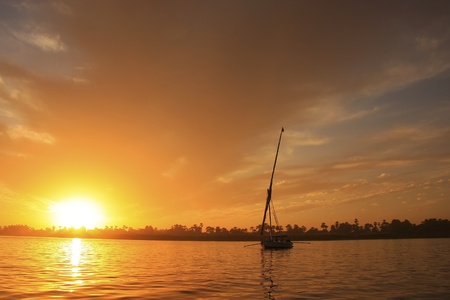 Felucca boat sailing on the Nile river at sunset, Luxor, Egyptの写真素材