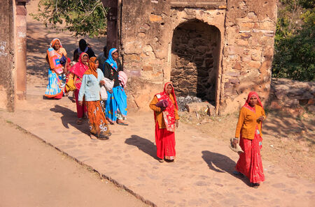 Indian women in colorful saris walking trhough the gate at Ranthambore Fort, Rajasthan, Indiaのeditorial素材