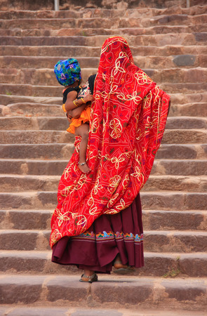 Indian women in colorful saris with a kid walking up the stairs at Ranthambore Fort, Rajasthan, Indiaのeditorial素材