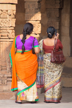 Indian women standing in courtyard of Quwwat-Ul-Islam mosque, Qutub Minar complex, Delhi, Indiaの写真素材