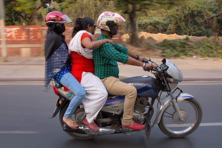 Three people on a motocycle driving in the street, New Delhi, India. Shot with blurred motion affect to show movement and speedのeditorial素材