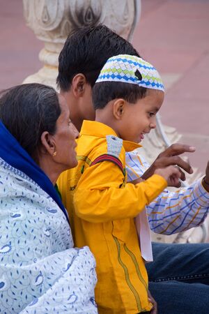 Indian boy with grandmother sitting at Jama Masjid in Delhi, India. The courtyard of the mosque can hold up to twenty-five thousand worshippersのeditorial素材