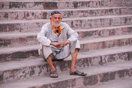 Muslim man sitting on the stairs of Jama Masjid in Delhi, India. The courtyard of the mosque can hold up to twenty-five thousand worshippers.のeditorial素材