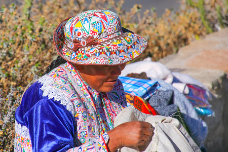 Local woman sitting at Mirador Cruz del Condor in Colca Canyon, Peru. It is very popular viewpoint for spotting Andean condors.のeditorial素材