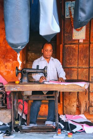 Local man making motorbike seat covers at Johari Bazaar street in Jaipur, Rajasthan, India. Jaipur is the capital and the largest city of Rajasthan.のeditorial素材