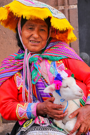 Local woman in traditional dress holding lamb in the street of Cusco, Peru. In 1983 Cusco was declared a World Heritage Site by UNESCOのeditorial素材
