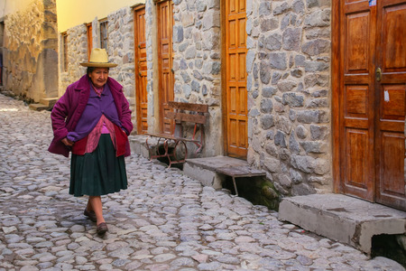 Local woman walking in the street of Ollantaytambo, Peru. Ollantaytambo was the royal estate of Emperor Pachacuti who conquered the region.のeditorial素材